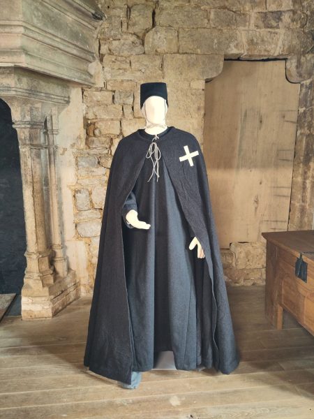 Un mannequin habillé d'une tenue gris foncé avec une croix blanche