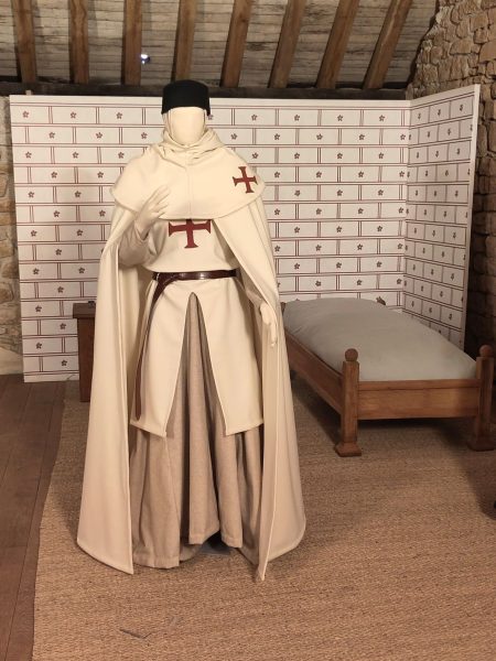 Un mannequin habillé d'une tenue de templier blanche avec des croix rouges