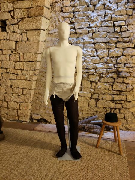 Mannequin habillé d'une sorte de caleçon en lin écru et de chausses en laine marron sur les jambes, vue de face