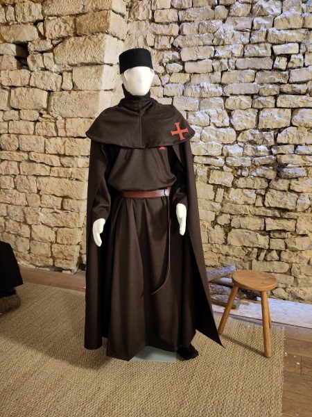 Un mannequin habillé d'un costume de templier marron avec des croix rouges