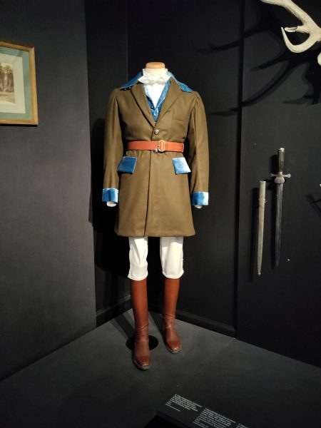 Tenue de chasse à courre composée d'une veste marron à revers turquoise, d'une culotte blanche, d'une ceinture en cuir et de bottes en cuir