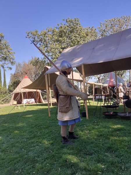 Homme en tenue de soldat médiéval, gambison écru, cotte bleue qui dépasse en bas
